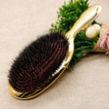 Gold wild boar bristle air cushion paddle hair brush with dense black bristles and ergonomic handle for detangling, smoothing, frizz control, scalp massage and daily hair care.