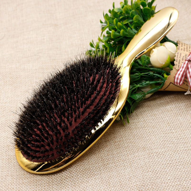 Gold wild boar bristle air cushion paddle hair brush with dense black bristles and ergonomic handle for detangling, smoothing, frizz control, scalp massage and daily hair care.