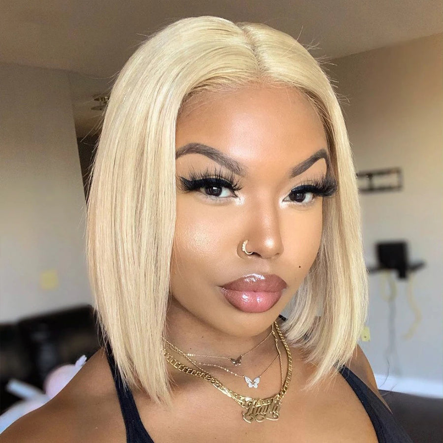 Woman with a blonde bob wig indoors 613 blonde wig, 613 lace front wig, platinum blonde wig, blonde bob wig, lace front bob wig, human hair bob wig, 100% human hair wig, platinum wig, icy blonde wig, straight bob wig, straight lace front wig, glueless wig, glueless lace front wig, blonde human hair wig, pre lightened wig, #613 wig, custom color wig, dyeable human hair wig, bleach safe wig, toneable wig, lace front human hair wig, short wig, bob hairstyle wig, luxury wig, premium wig, natural hairline wig, b