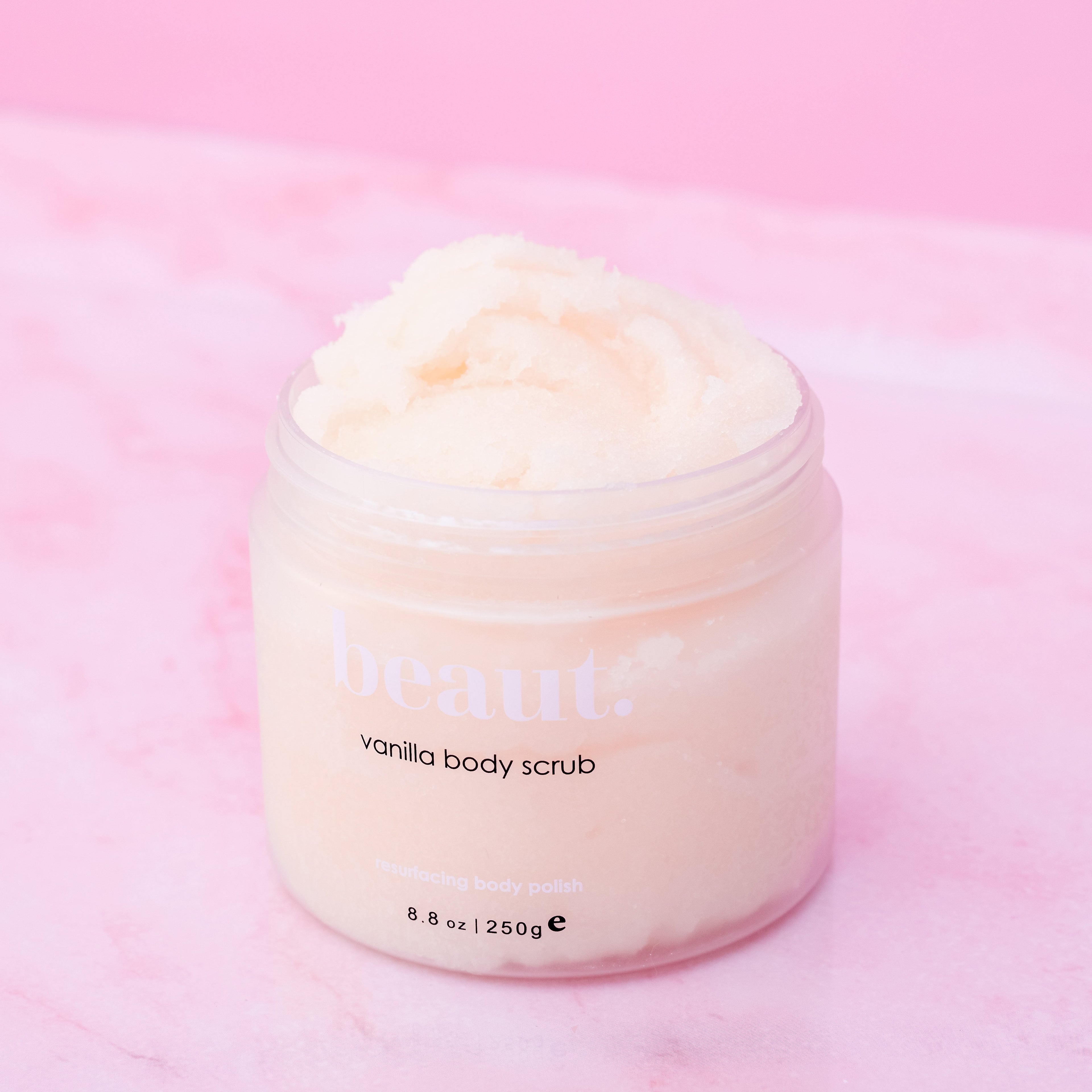 Beaut. Vanilla Body Scrub – exfoliating resurfacing body polish, 8.8 oz luxury skincare scrub for smooth, soft, radiant skin on pink background