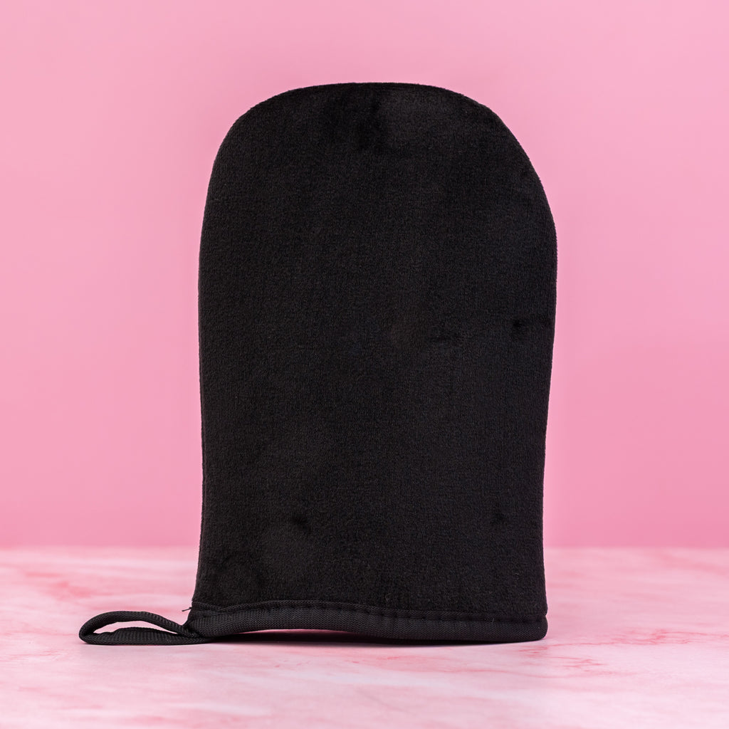 Black reusable self-tanning mitt applicator glove for streak-free sunless tanning lotion, mousse, cream and gel on pink background – Thai Luxury Hair