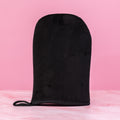 Black reusable self-tanning mitt applicator glove for streak-free sunless tanning lotion, mousse, cream and gel on pink background – Thai Luxury Hair
