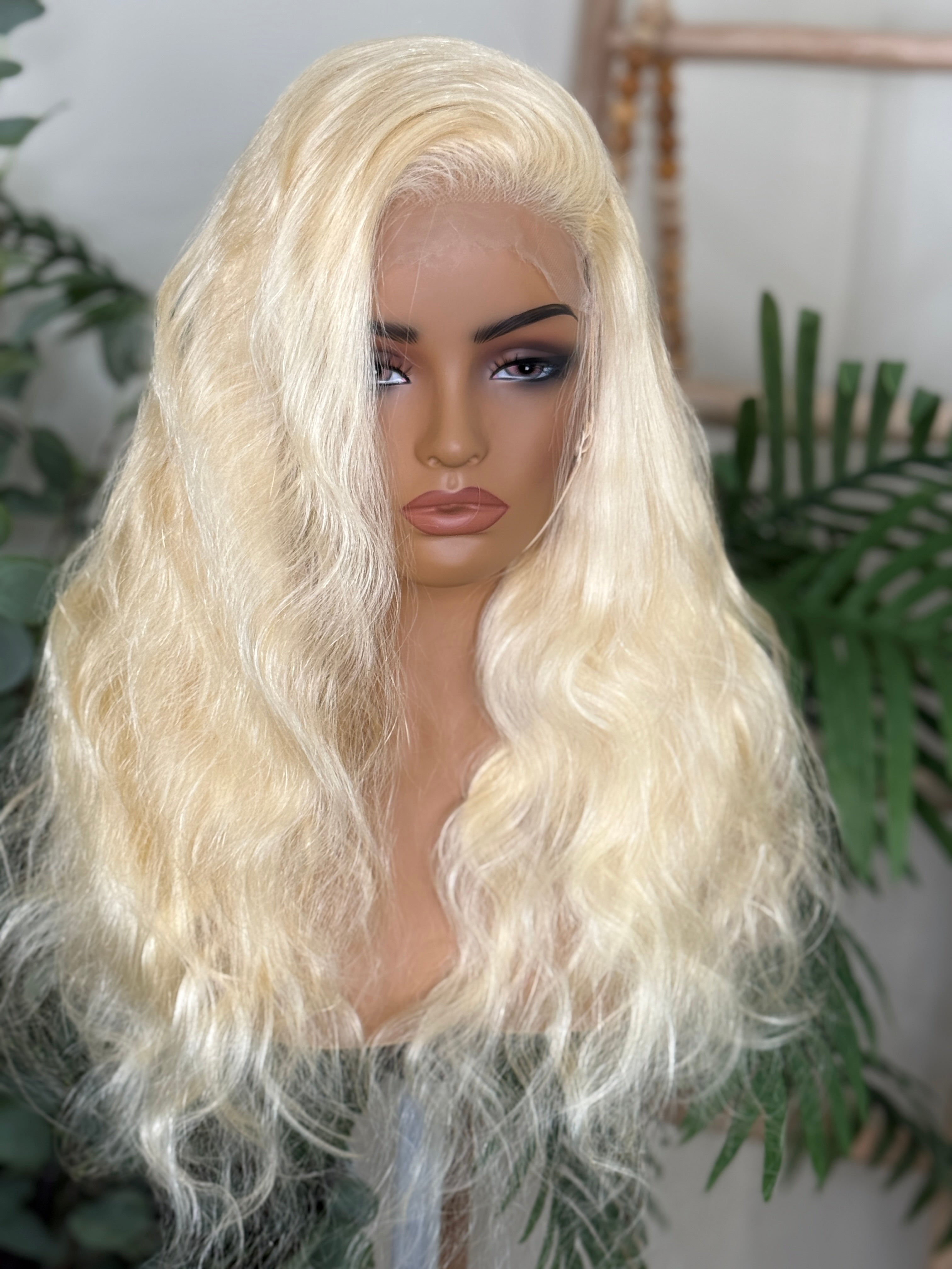 Blonde wig on a mannequin head with a blurred indoor background Blonde 613 Virgin 100% Human Hair 5x5 Closure or 13x4 Adjustable Glueless Lace Frontal Wig