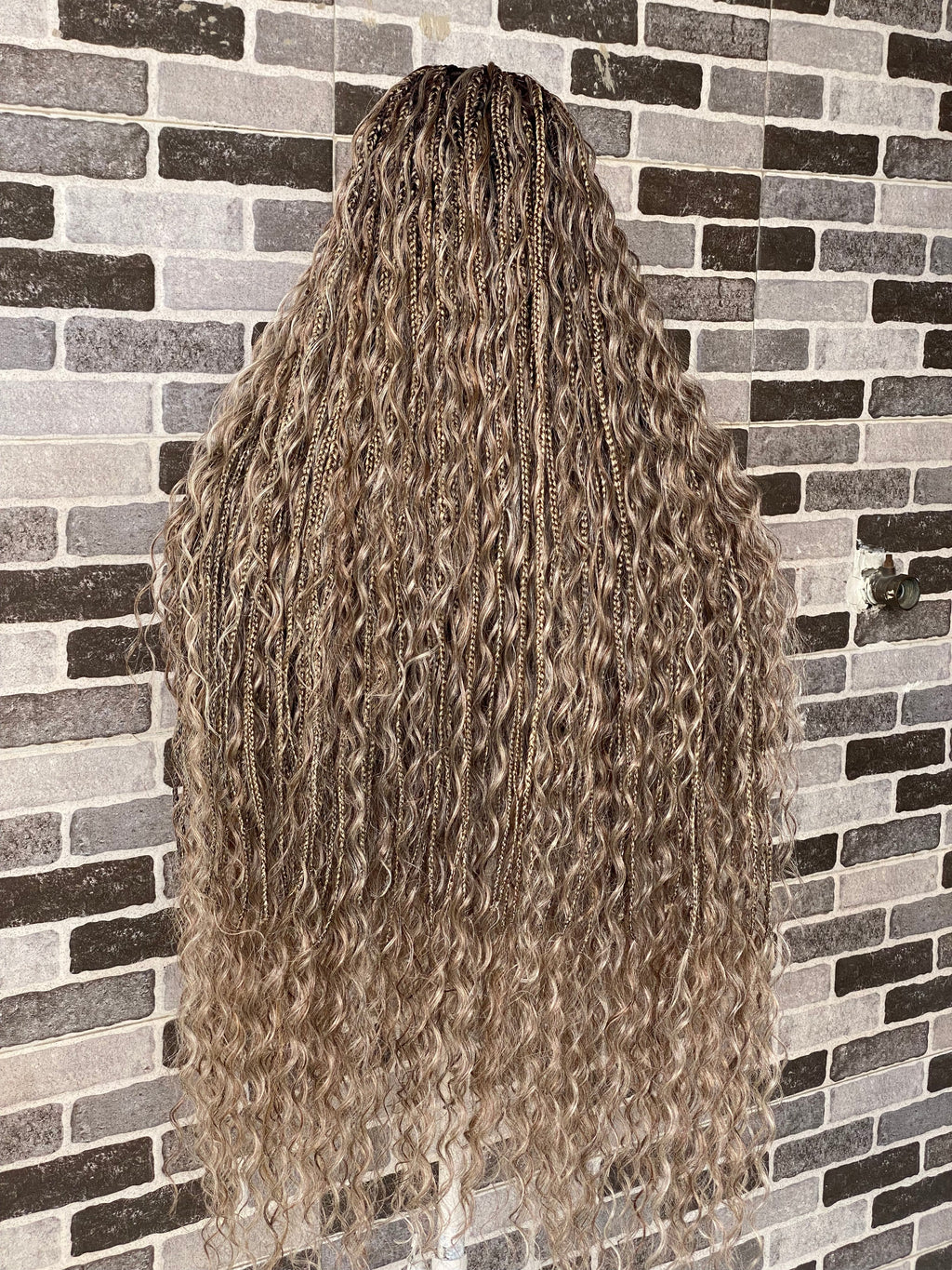 Long, wavy hair styled in a 这种方式 against a brick wall. Bohemian Knotles custom color Full lace wig (Mix color)
