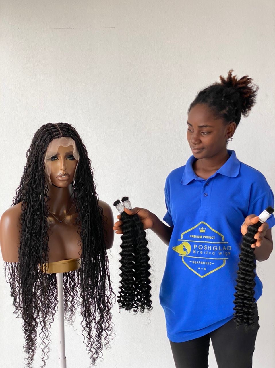 Person holding hair extensions next to a mannequin with long hair, wearing a blue shirt with a logo. Bohemian humanhair Knotless-Ready to ship (Tara)