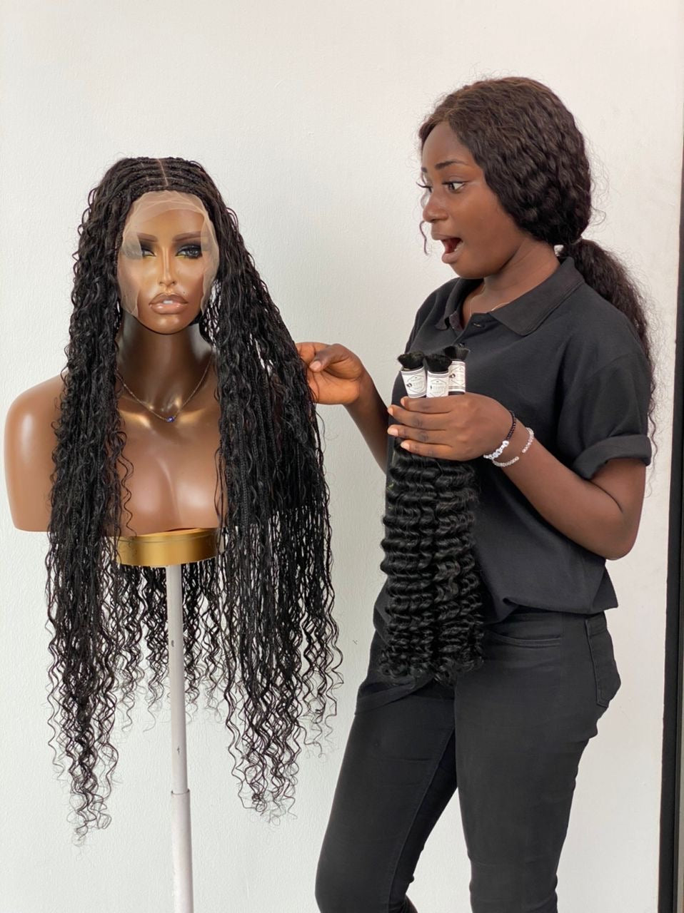 Person holding a set of hair extensions next to a mannequin with long, wavy hair. Bohemian humanhair Knotless-Ready to ship (Tara) Bohemian Human Hair Knotless-Ready to ship (Tara) 100% Human Hair and Stretchable HD Full Lace Cap