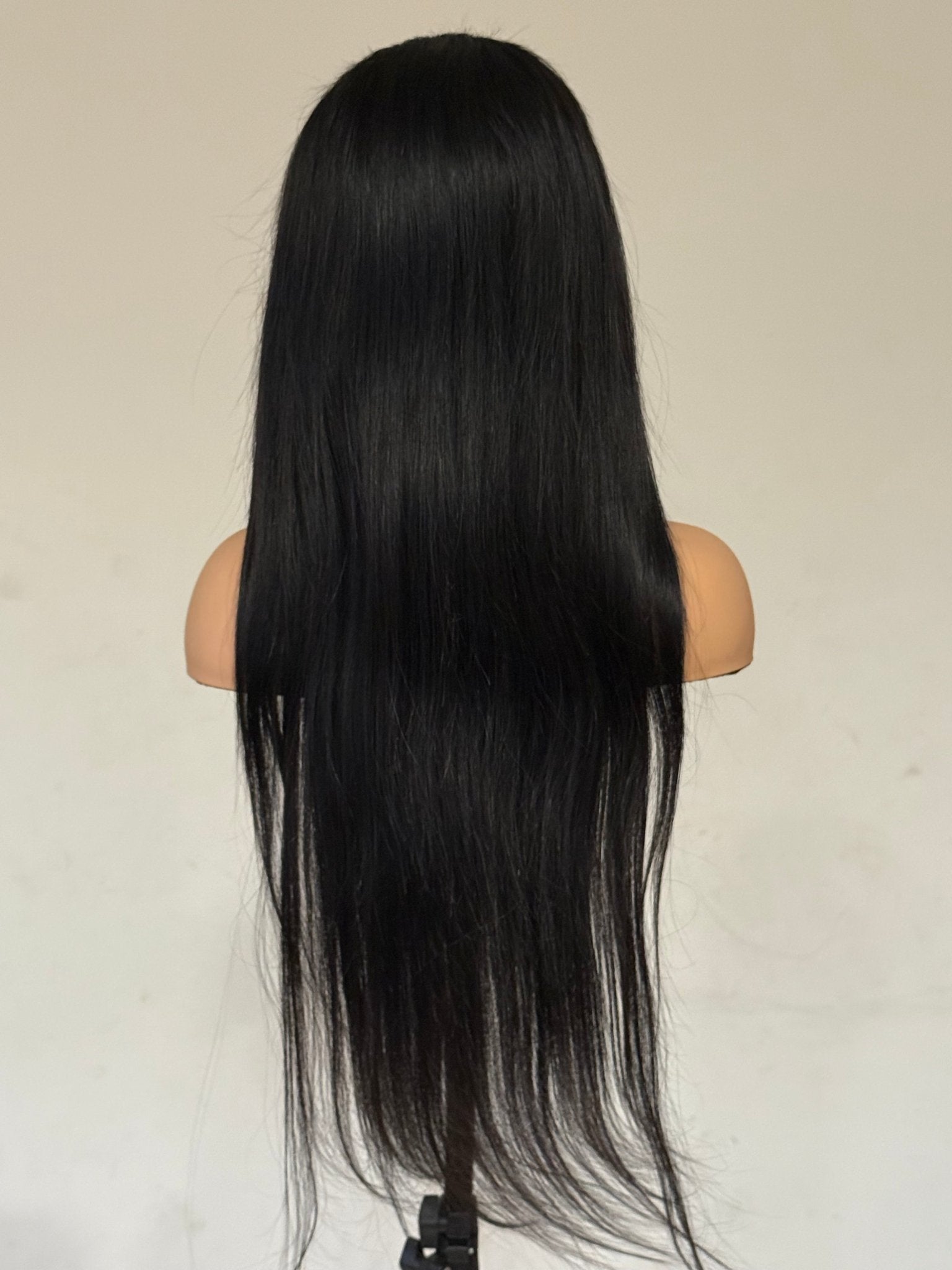 Black wig on a mannequin head against a plain background brazilian straight wig, brazilian straight lace front wig, straight lace front wig, straight human hair wig, natural black wig, black lace front wig, human hair wig, 100% human hair wig, glueless wig, ready to wear wig, natural hairline wig, realistic lace front wig, premium human hair wig, luxury wig, long straight wig, long black wig, heat safe wig, everyday wig, date night wig, photo ready wig
