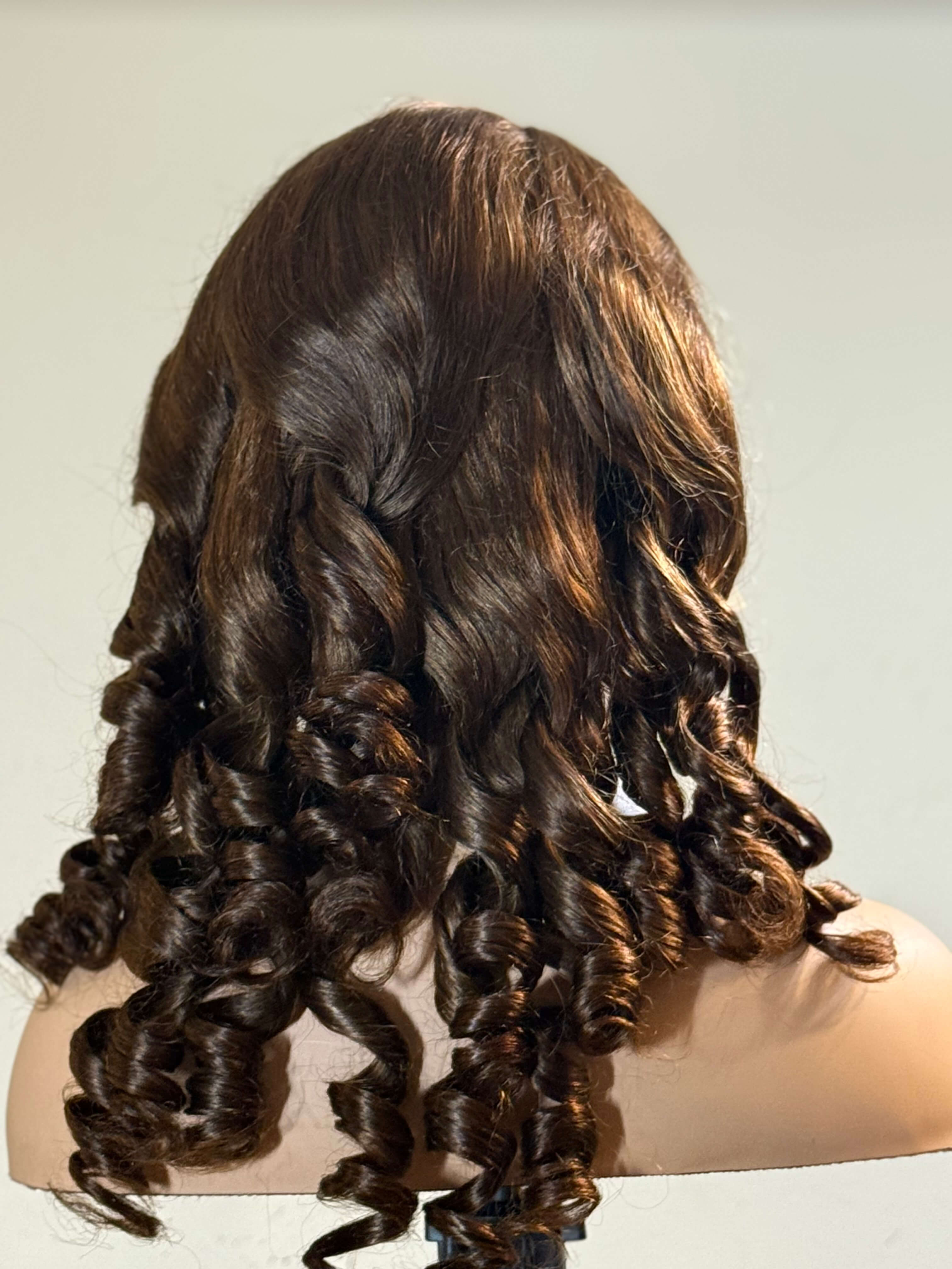 Brown hair extensions on a mannequin head against a plain background brown sugar bounce, chocolate brown lace front wig, chocolate brown human hair wig, brown lace front wig, brown human hair wig, brunette wig, brunette lace front wig, chocolate wig, rich brown wig, mocha brown wig, caramel brown wig, warm brown wig, chocolate brown hair wig, long loose wave wig, loose wave human hair wig, loose wave lace wig, luxury brown wig, premium human hair wig, natural part wig, realistic lace front wig, seamless hai