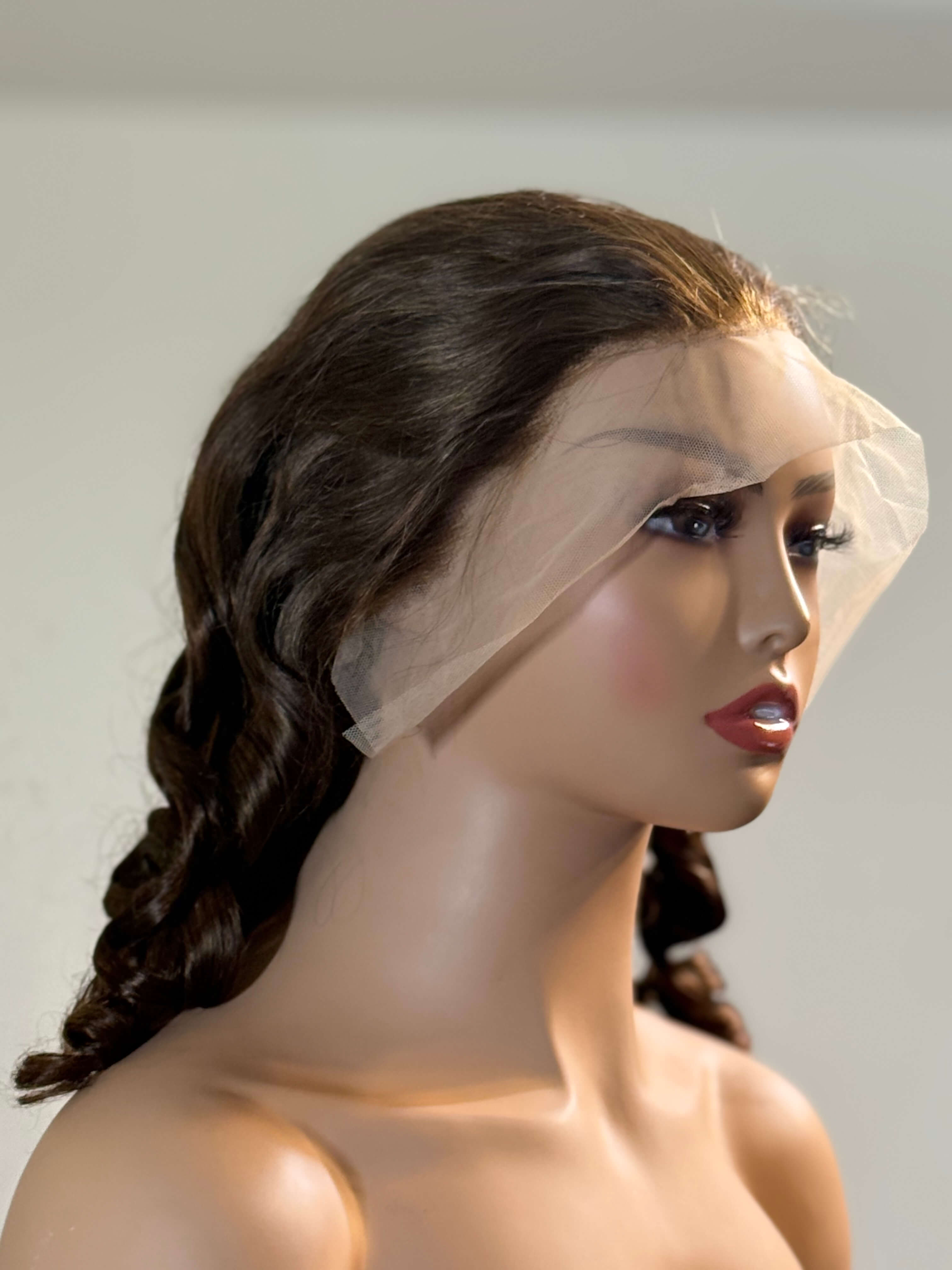 Mannequin head with a dark brown wig and a white veil on a plain background brown sugar bounce, chocolate brown lace front wig, chocolate brown human hair wig, brown lace front wig, brown human hair wig, brunette wig, brunette lace front wig, chocolate wig, rich brown wig, mocha brown wig, caramel brown wig, warm brown wig, chocolate brown hair wig, long loose wave wig, loose wave human hair wig, loose wave lace wig, luxury brown wig, premium human hair wig, natural part wig, realistic lace front wig, seaml