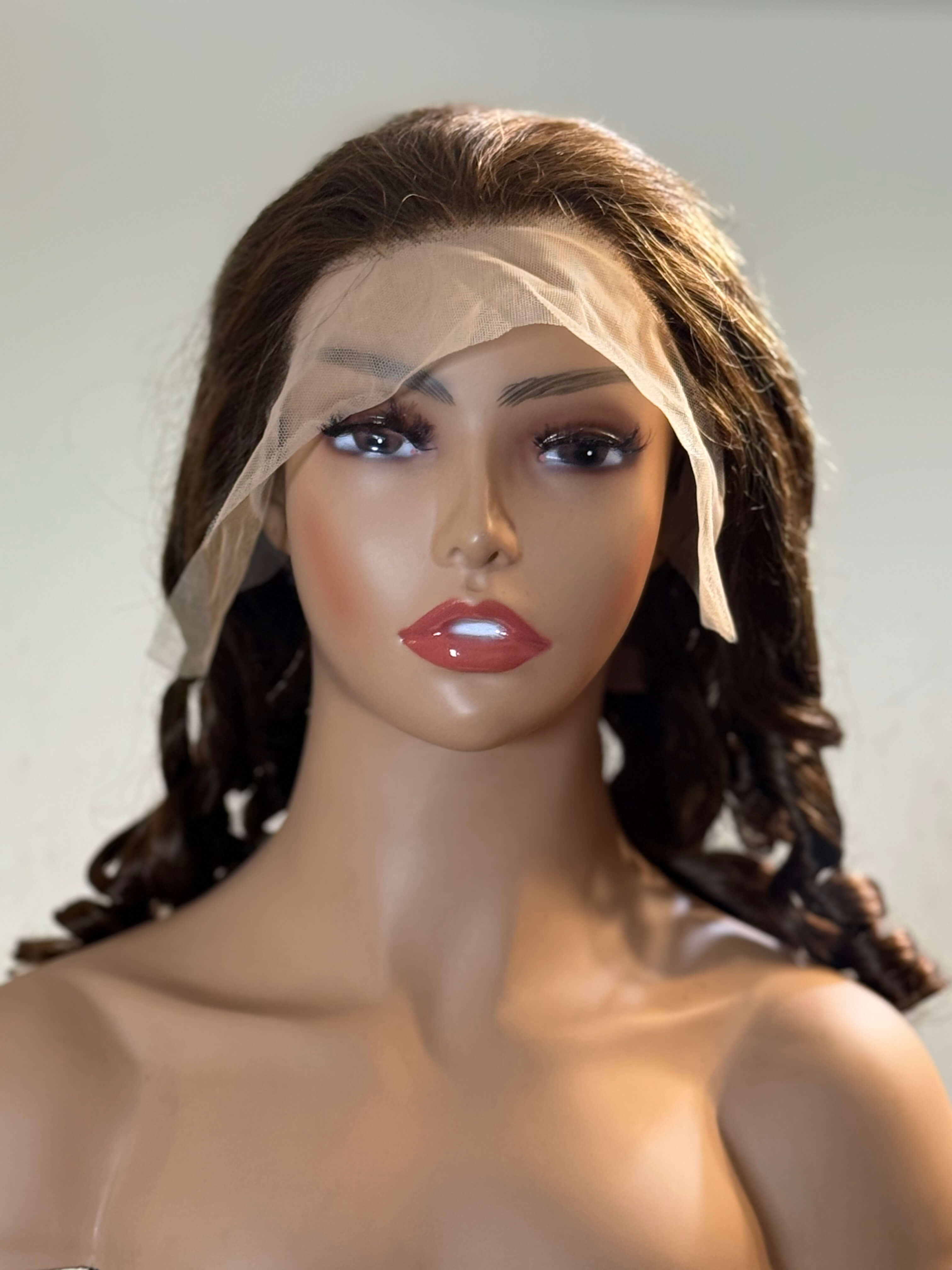 Mannequin head with a brown wig and white mesh veil on a plain background brown sugar bounce, chocolate brown lace front wig, chocolate brown human hair wig, brown lace front wig, brown human hair wig, brunette wig, brunette lace front wig, chocolate wig, rich brown wig, mocha brown wig, caramel brown wig, warm brown wig, chocolate brown hair wig, long loose wave wig, loose wave human hair wig, loose wave lace wig, luxury brown wig, premium human hair wig, natural part wig, realistic lace front wig, seamles