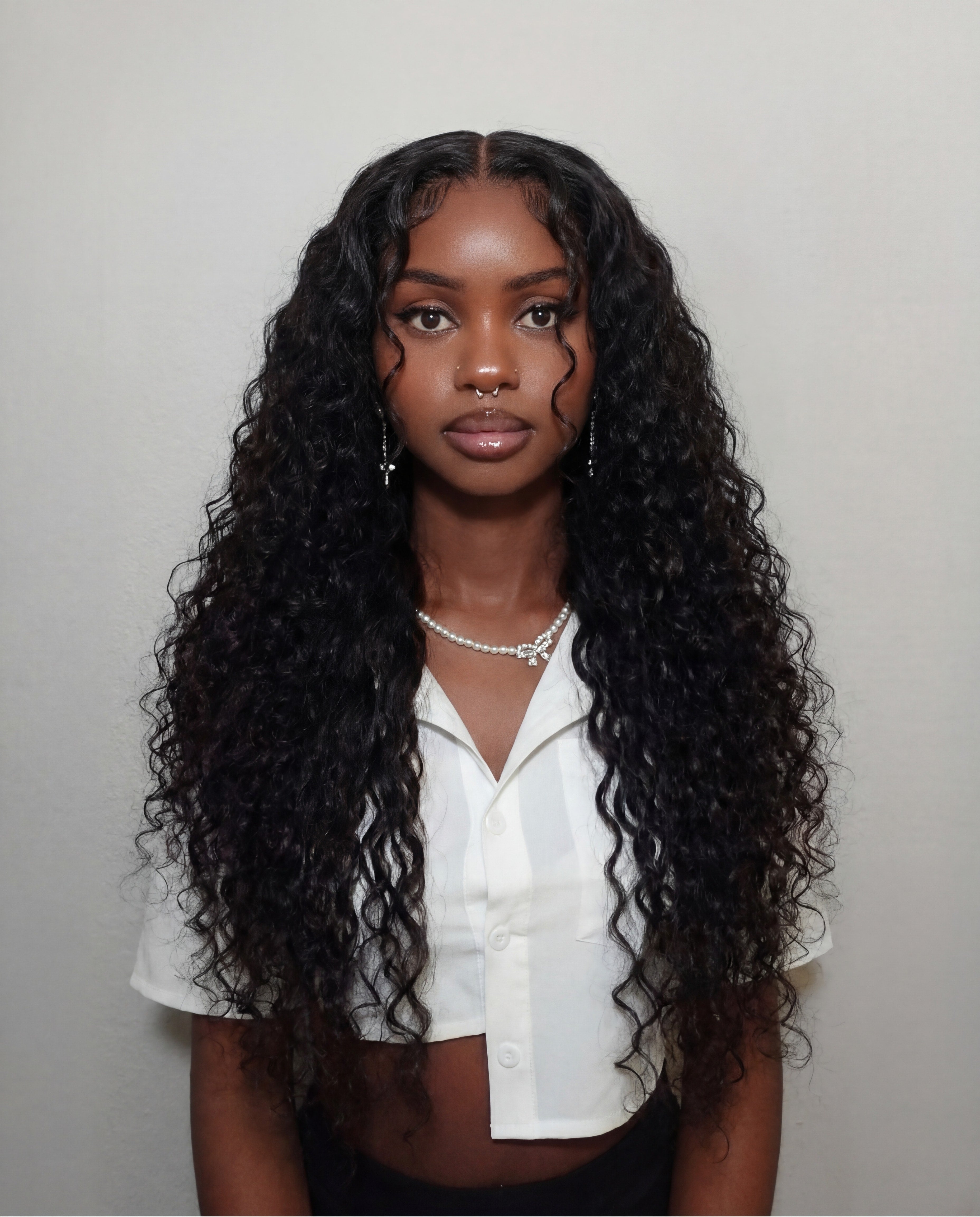 Woman with long, curly black hair wearing a white blouse against a plain background Burmese Curly Virgin Hair - 100% Virgin Human Hair – Soft, full, and beautifully textured HD Lace Wig Glueless Wig