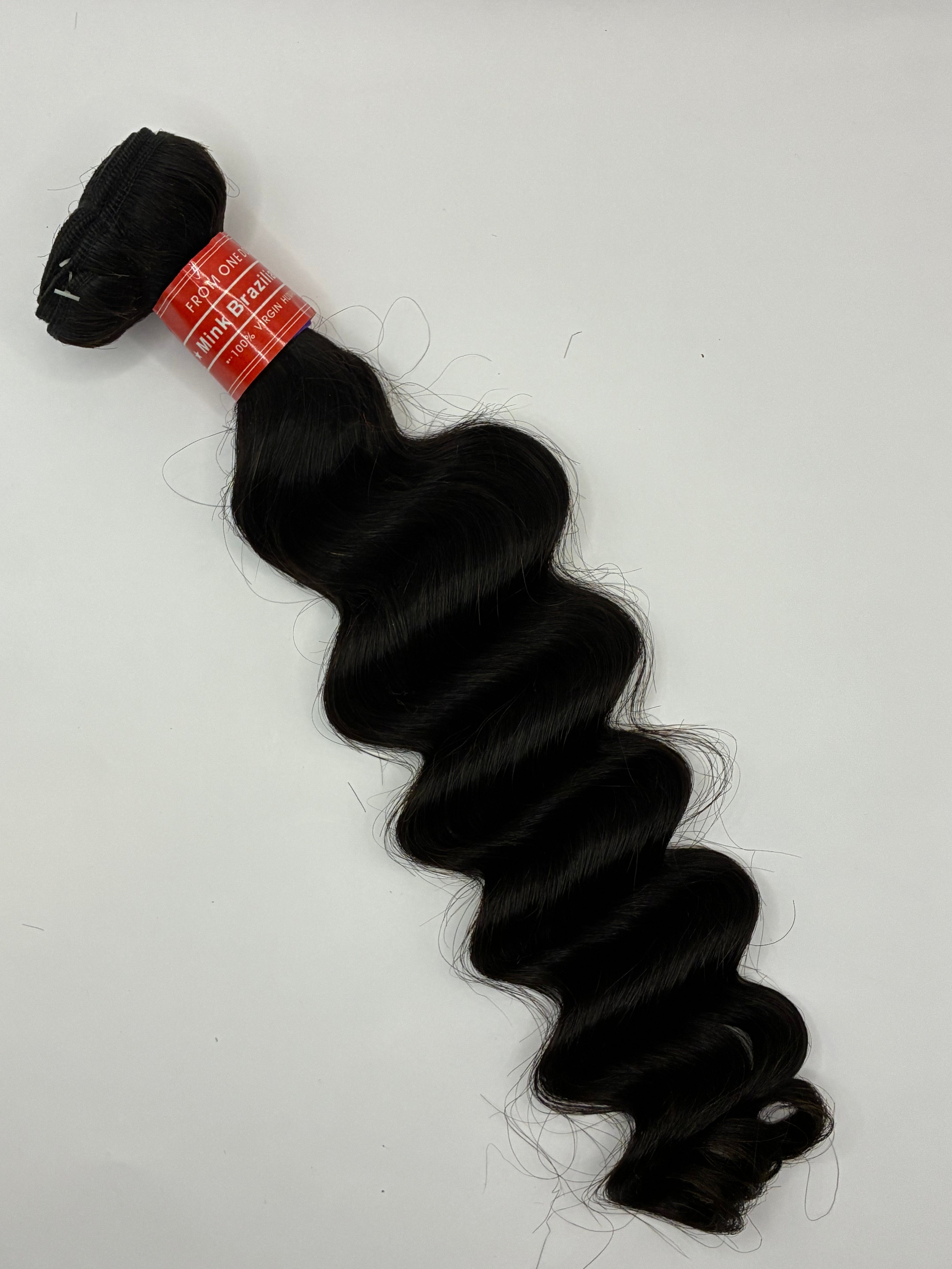 Black hair bundle with a red label on a white background Shop premium Loose Deep Virgin Human Hair Bundles in Natural Black. Soft, bouncy waves, minimal shedding, natural luster, and long-lasting luxury quality for sew-ins, wigs, and protective styles. Crown'd Cuties Loose Deep Virgin Human Hair Bundle in Natural Black featuring soft, voluminous loose deep waves with natural luster and healthy shine.