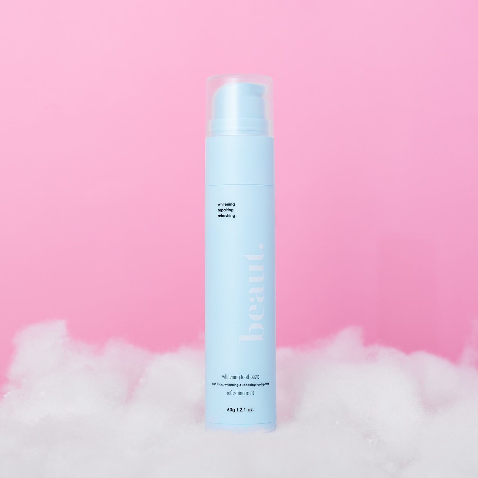 beaut. Mint Whitening Toothpaste in pastel blue pump bottle on soft pink background with white fluffy clouds, non-toxic refreshing mint oral care, 60g 2.1 oz