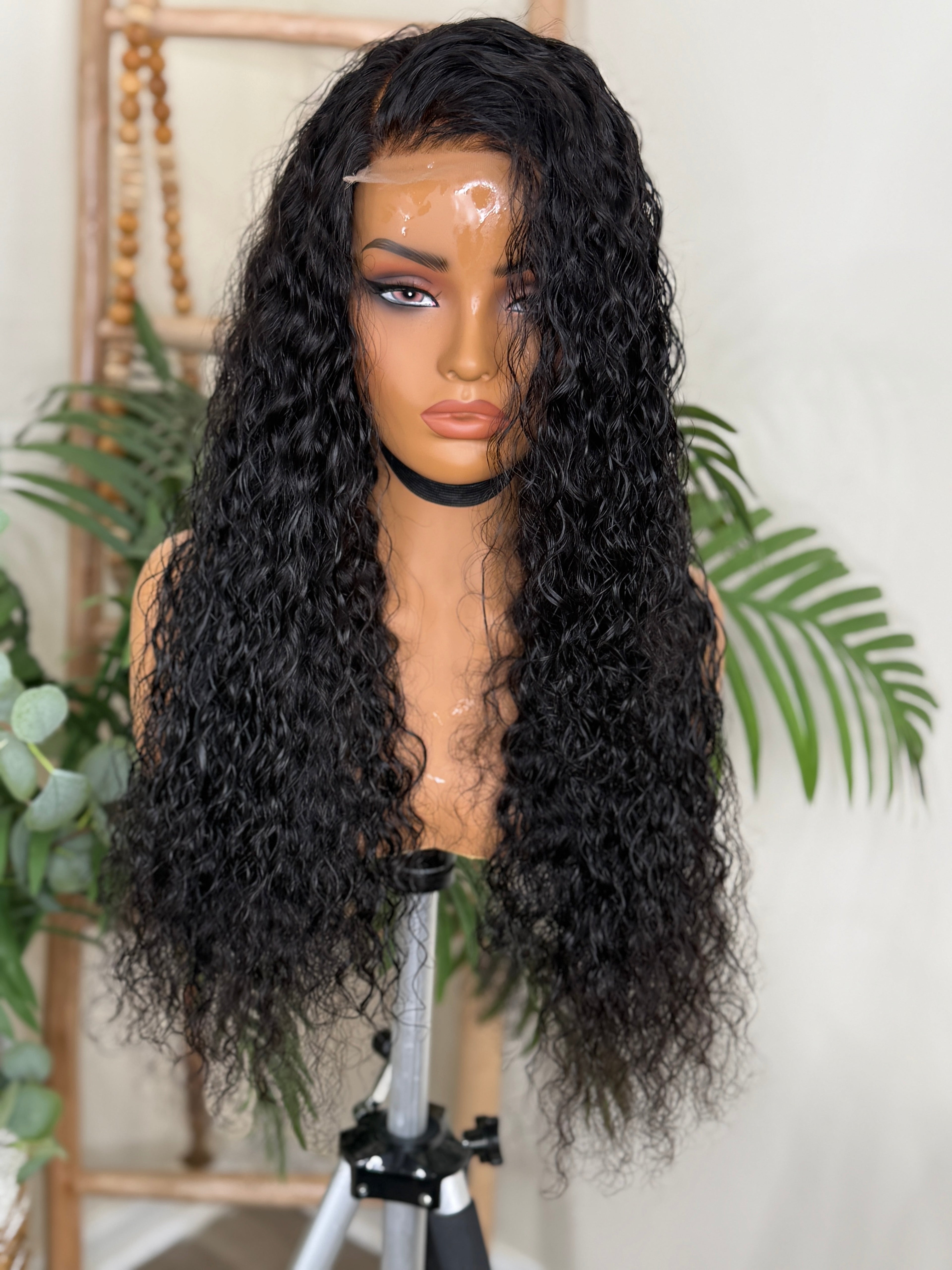 Black curly wig on a mannequin head with a white background Exotic Curl Virgin Hair - 100% Virgin Human Hair – Bold, voluminous, and full of life HD Glueless Lace WIg