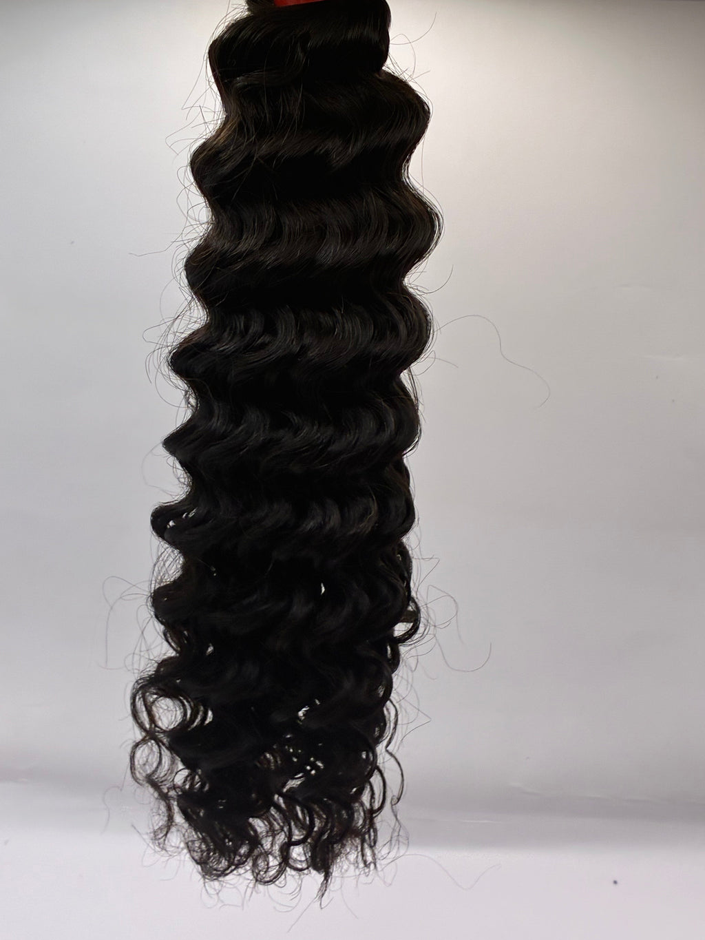 Black hair extensions with loose curls on a white background