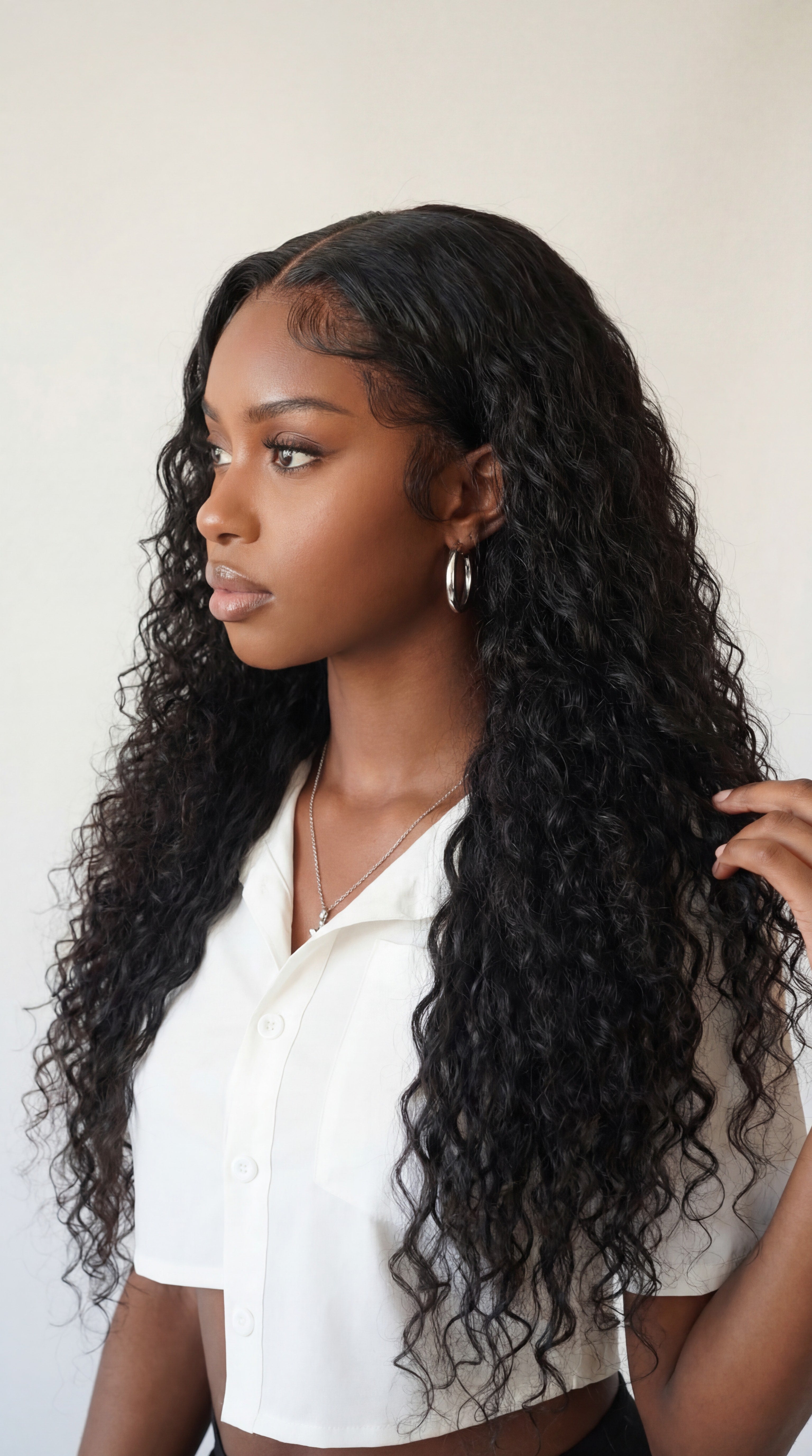 Woman with long, wavy black hair wearing a white top against a plain background Italian Curl Virgin Hair Wig - Made with 100% Virgin Human Hair