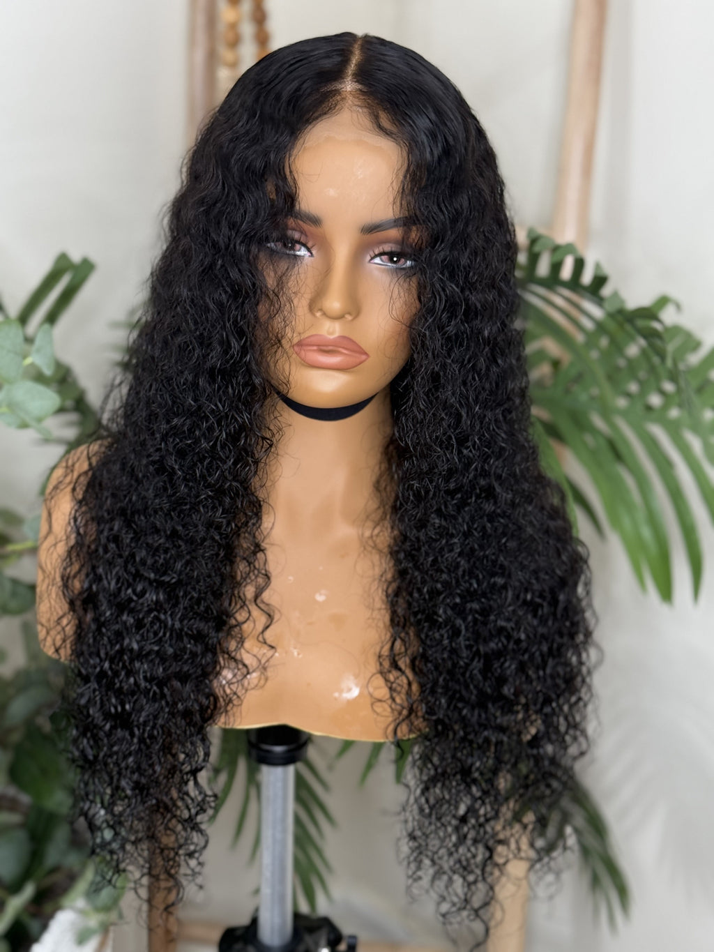 Black curly wig on a mannequin head with a white background Italian Curl Virgin Hair Wig - Made with 100% Virgin Human Hair