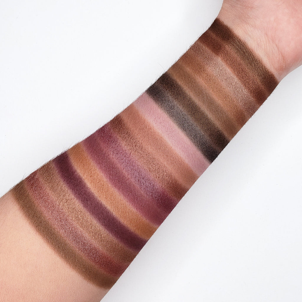 Nude and brown eyeshadow swatches on a person's arm