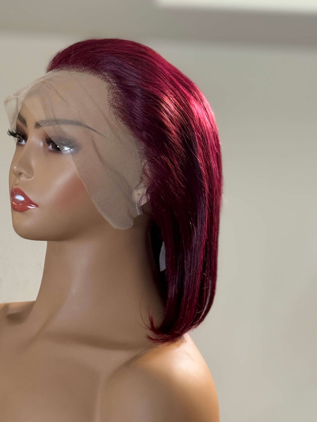 Mannequin head with a red wig on a plain background. burgundy wig, burgundy red wig, burgundy lace front wig, burgundy human hair wig, wine red wig, wine color wig, red lace front wig, red human hair wig, red bob wig, burgundy bob wig, burgundy lace wig, burgundy human hair bob wig, straight bob wig, straight lace front wig, straight human hair wig, human hair bob wig, lace front bob wig, bob lace wig, chic bob wig, sleek bob wig, short human hair wig, short lace front wig, short wig, bob hairstyle wig, bob