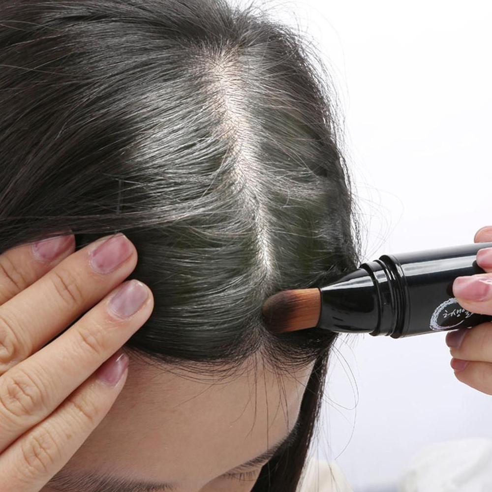 Temporary hair color brush applicator applying washable black brown hair color wax to gray roots for quick DIY root touch-up and temporary gray coverage.