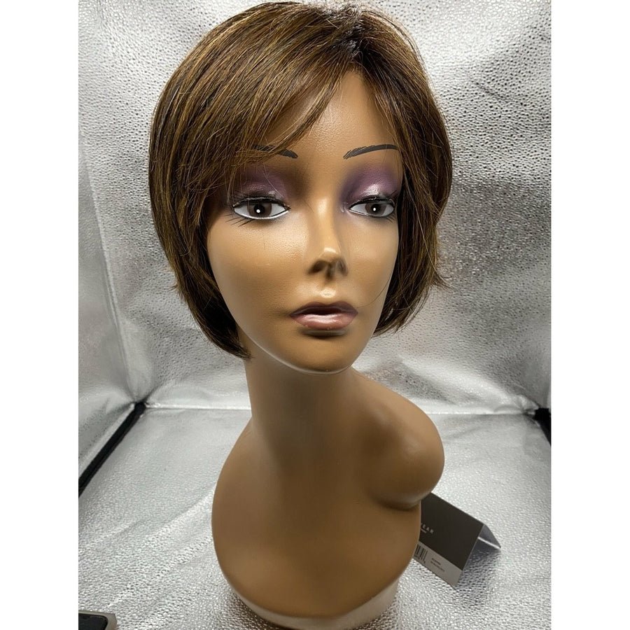 A short brown wig with side-swept bangs displayed on a mannequin head and neck against a textured silver backdrop.