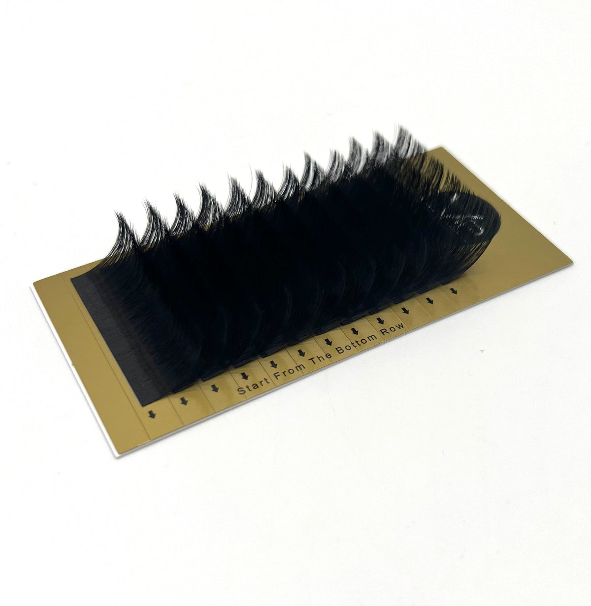 False eyelashes on a gold card with measurement scale on a white background
