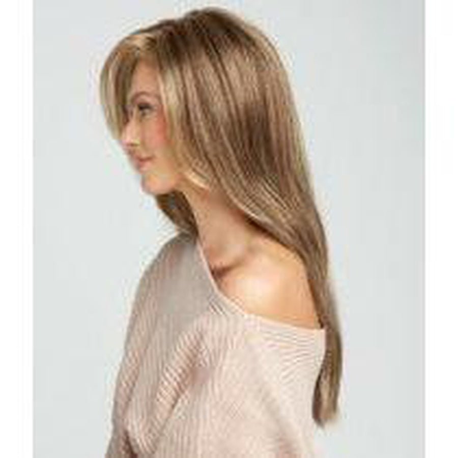 A woman shown in side profile wearing a shoulder-length straight wig with layered bangs and warm blonde highlights, paired with a light beige knit top against aMiles of Style - Wig by Raquel Welch