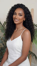 Woman with long, curly black hair wearing a white top in a natural setting. Italian Curl Wefted Bundle