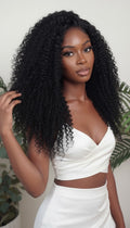 Woman with long, curly black hair wearing a white top against a neutral background