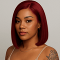 Woman with red hair and a tattoo on her arm against a neutral background. burgundy wig, burgundy red wig, burgundy lace front wig, burgundy human hair wig, wine red wig, wine color wig, red lace front wig, red human hair wig, red bob wig, burgundy bob wig, burgundy lace wig, burgundy human hair bob wig, straight bob wig, straight lace front wig, straight human hair wig, human hair bob wig, lace front bob wig, bob lace wig, chic bob wig, sleek bob wig, short human hair wig, short lace front wig, short wig