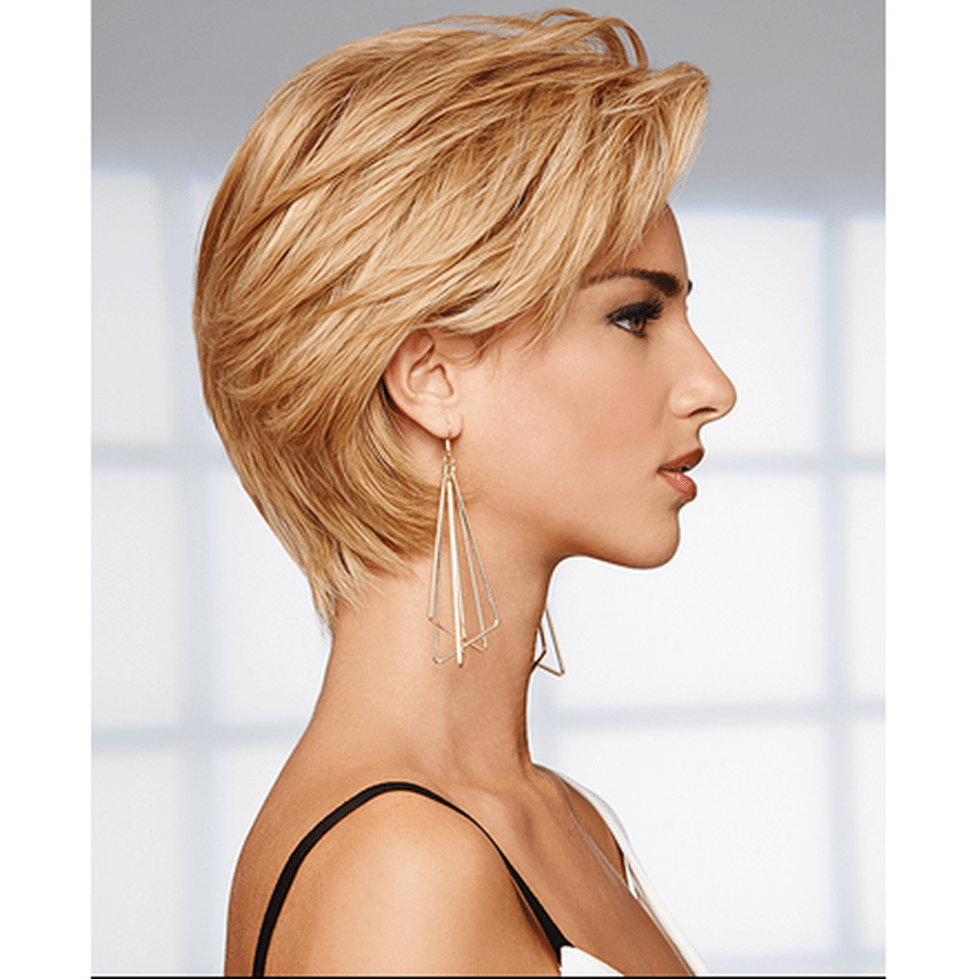 A woman shown in side profile wearing a short, layered blonde wig and long geometric dangling earrings against a soft light gray background.