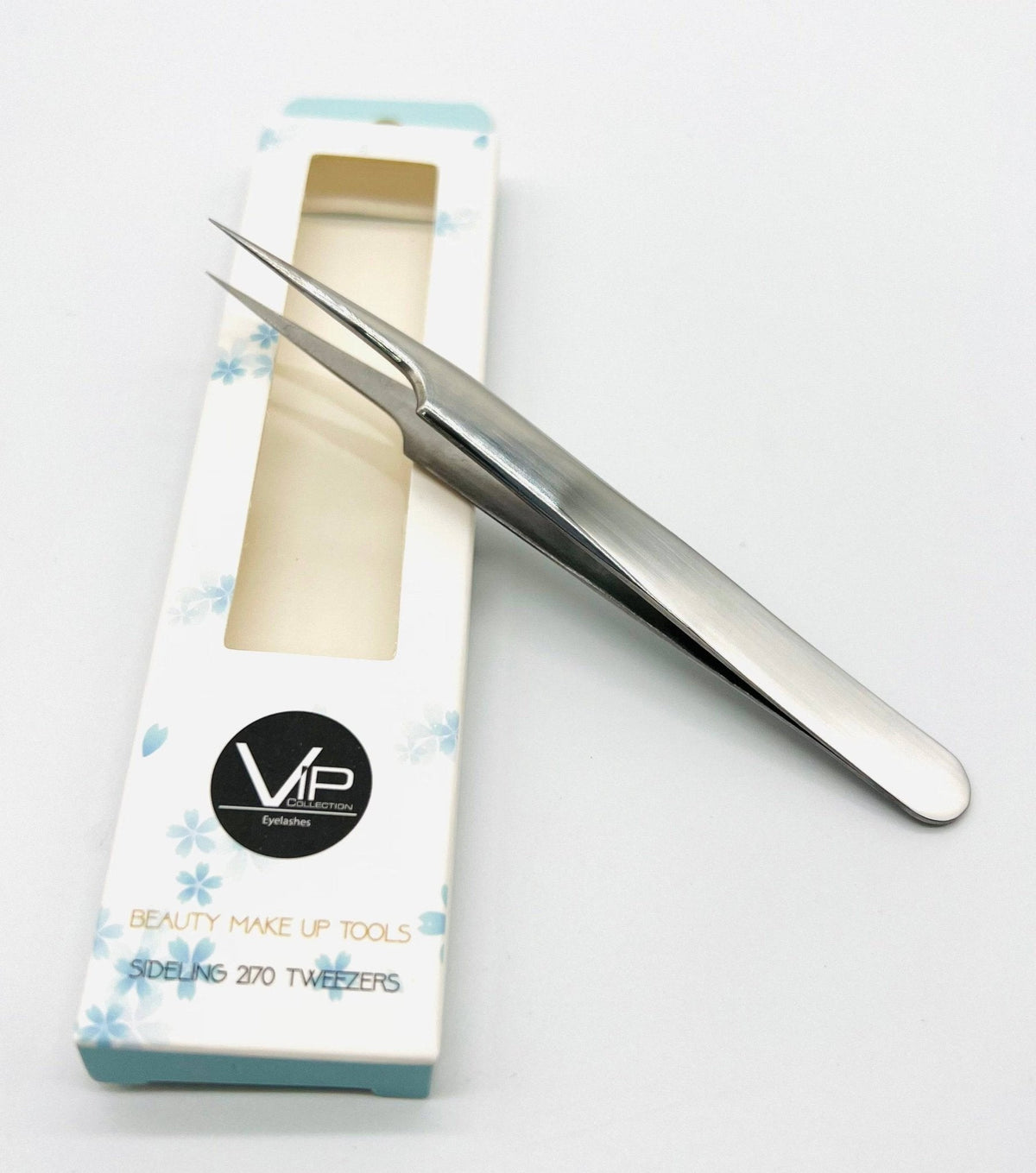 Metal tweezers on a white background with a branded box.