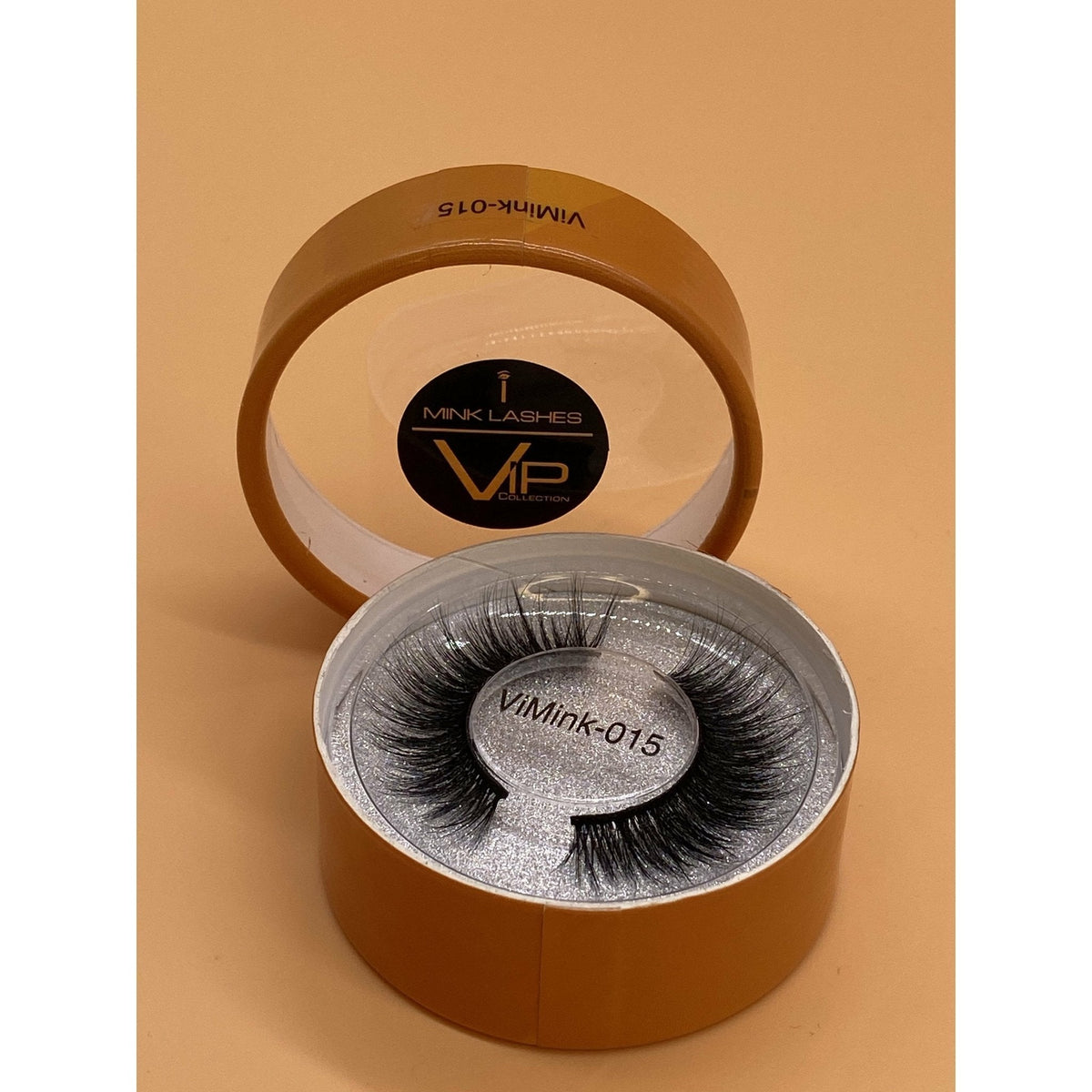 Open brown box containing false eyelashes with 'VIMink' branding on a beige background