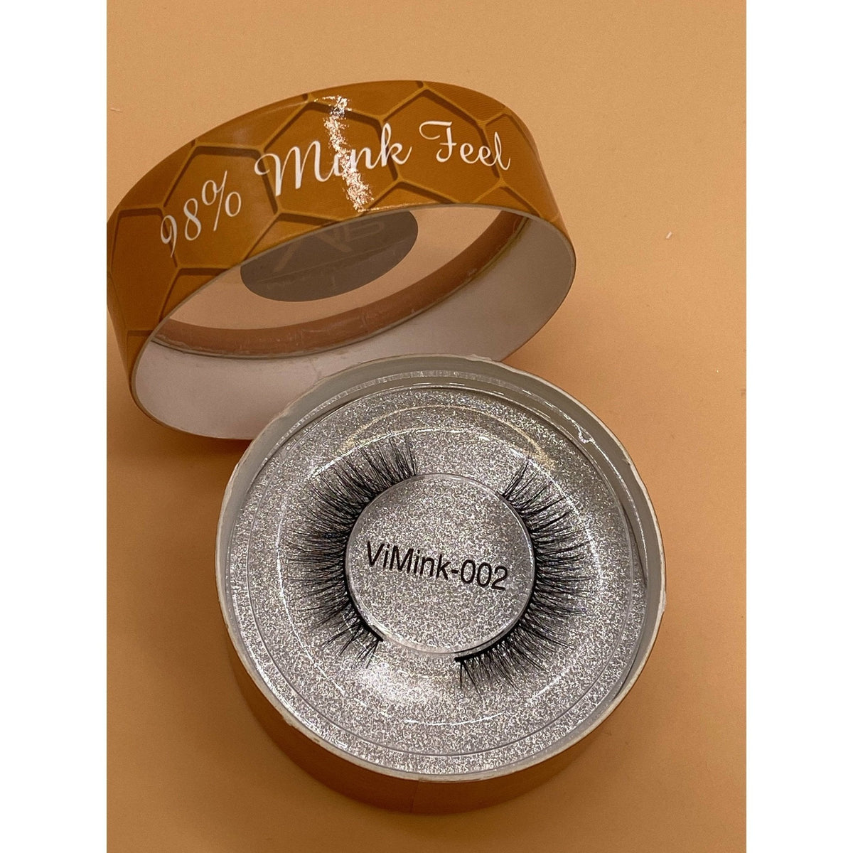 Eyelash packaging with 'ViMink 002' on a brown background